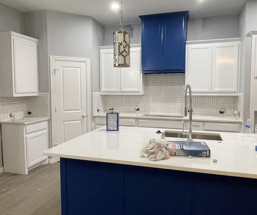 Kitchen remodeling project with white cabinets and a blue island by Prem's Handyman Service